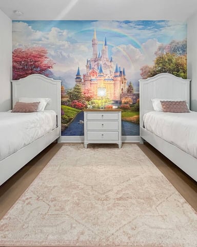 Twin bedroom with white beds, castle mural, and princess-themed wall art
